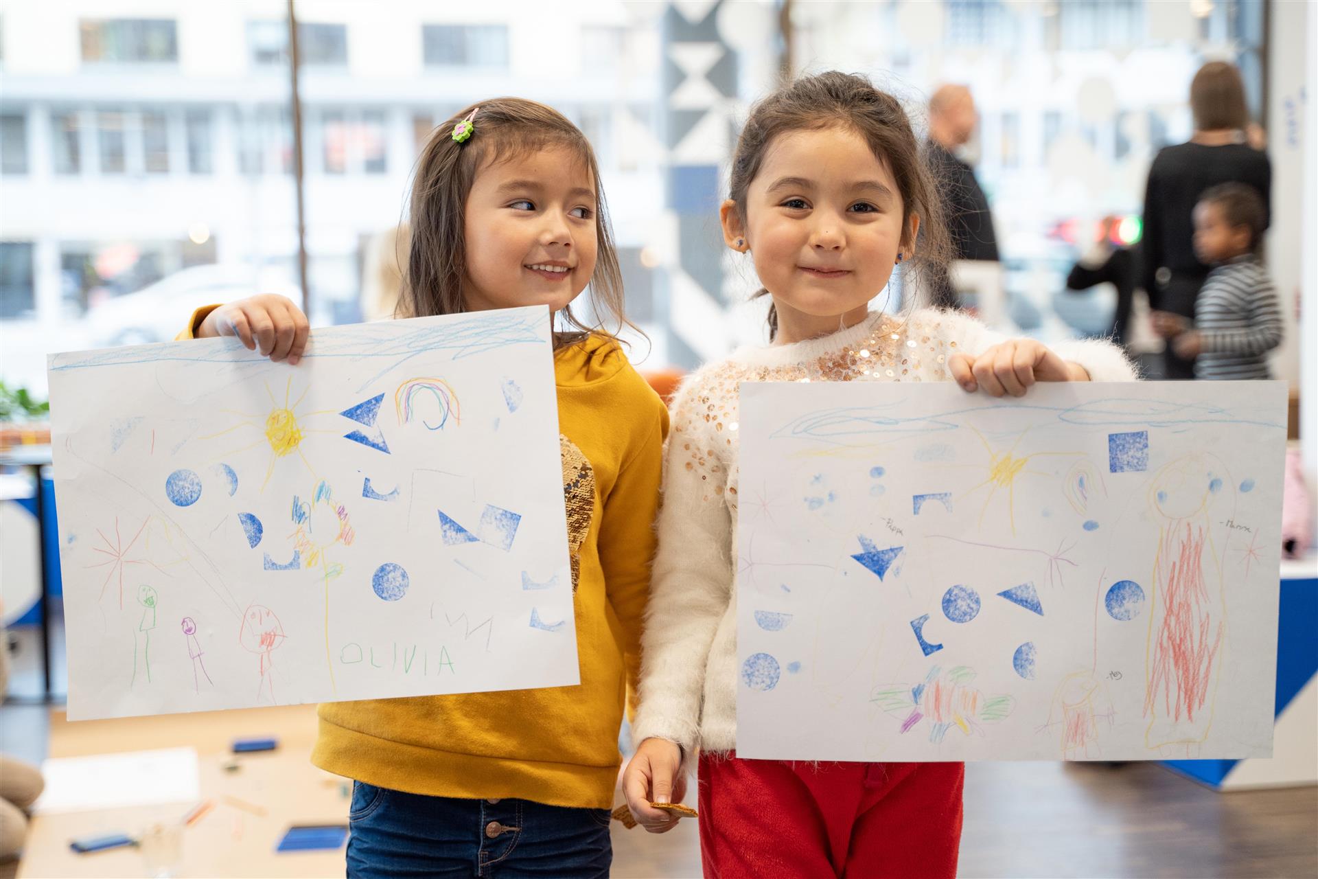 To barn som holde hver sin tegning i Bylaben